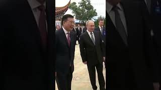 Xi and Putin look at a photo exhibition on Russia-China ties by state news agency Xinhua and TASS
