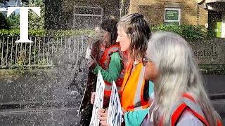 Just Stop Oil protesters drenched while slowing traffic in London