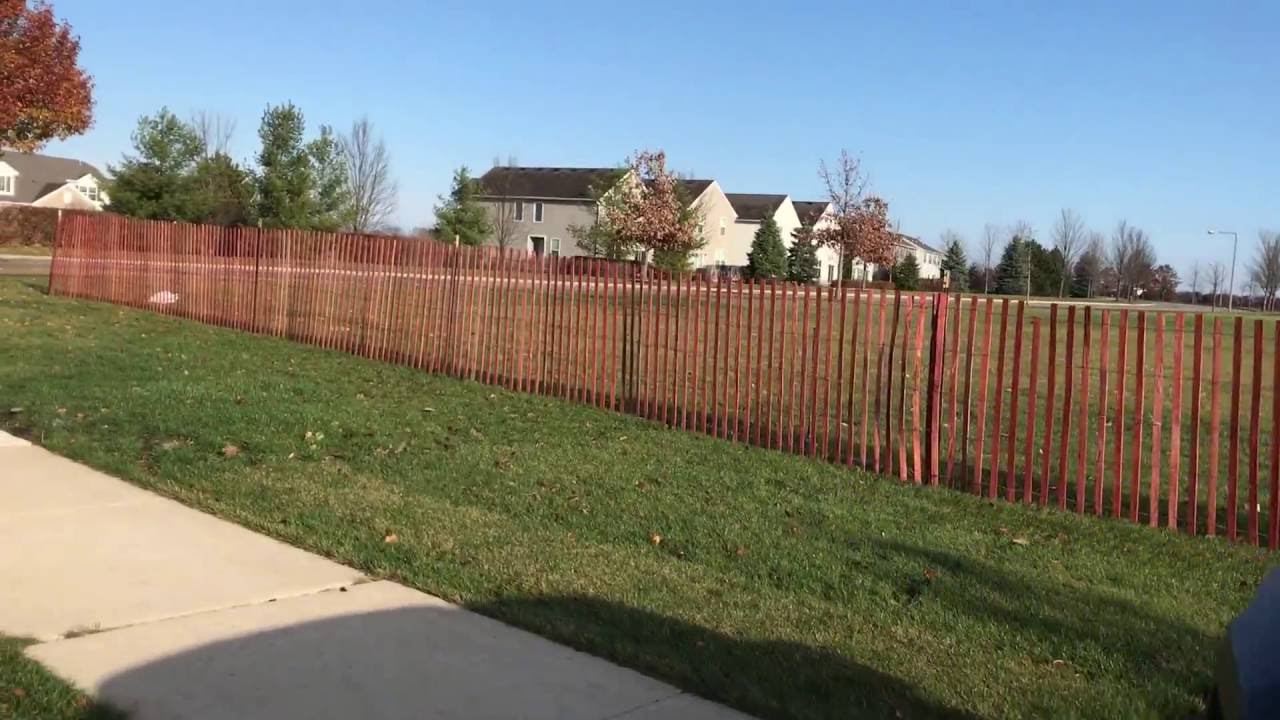 Wood snow fence installation - YouTube