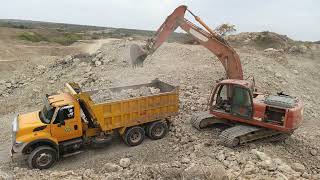 : Dump Truck Loaded Stones with Doosan Excavator