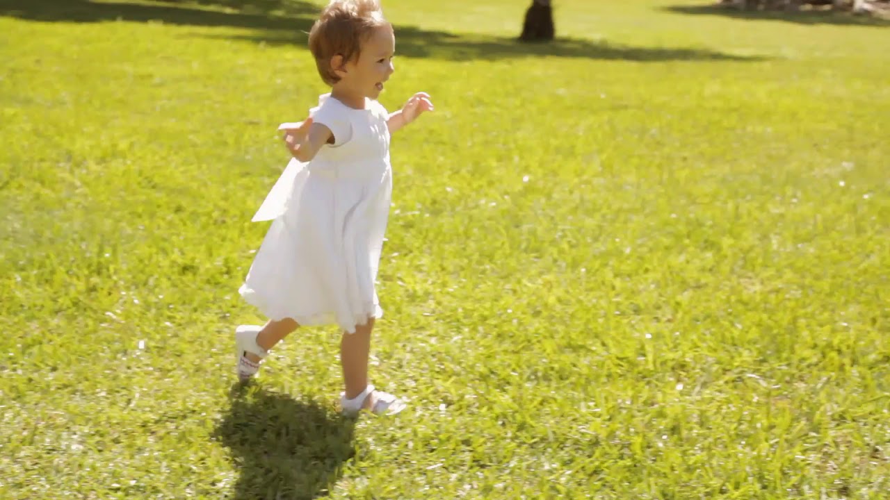 pan shot of baby walking in park