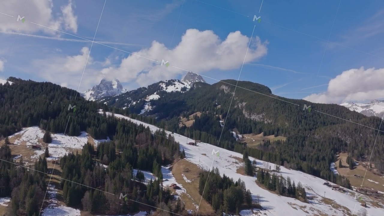 Aerial view capturing snow covered Gstaad mountainside, pine forests blanketing scenic alpine