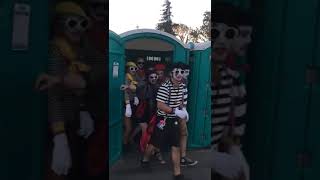 Ten Mimes walk out of a porta potty