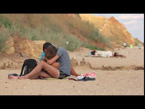 young couple relaxing on the beach and kissing passionate kisses