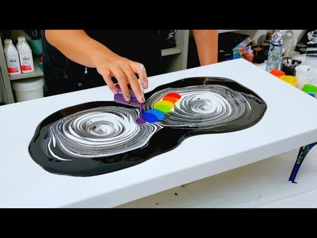 Premium AI Image  A hand is pouring paint over a colorful rainbow.