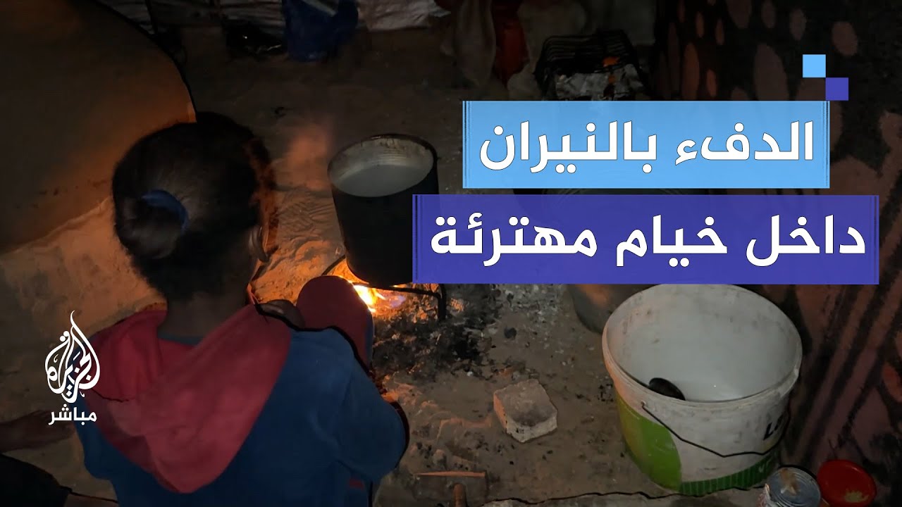 عائلة نازحة تستخدم النيران لتدفئة نفسها من البرد