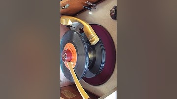 Trav-Ler 3 speed automatic record player playing a stack of 45 RPM records.