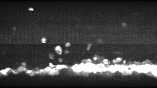 Slow motion sand particle splashing into sand bed