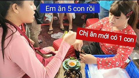 DIVA Cát Thy và Giáng Tiên review món ốc nhồi thịt và thịt xiên que nướng của gian hàng kế bên.