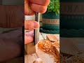Carving a small piece of light wood carefully with a sharp chisel to shape a tiny craft object