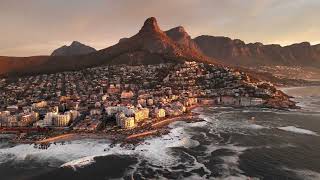 A breathtaking aerial view of a coastal city surrounded by majestic mountains