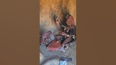 Himba woman uses aromatized smoke to "wash" clothing #namibia #himba #tribe