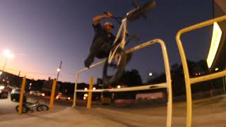 BMX rider plants front and rear pegs on handrail then falls back and bike lands on filmer (Angle 2)