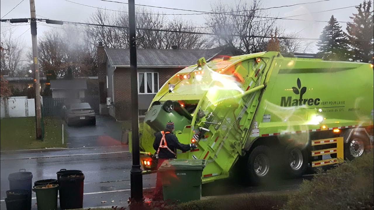 McNeilus GFL rear loader garbage truck in action collecting yard waste