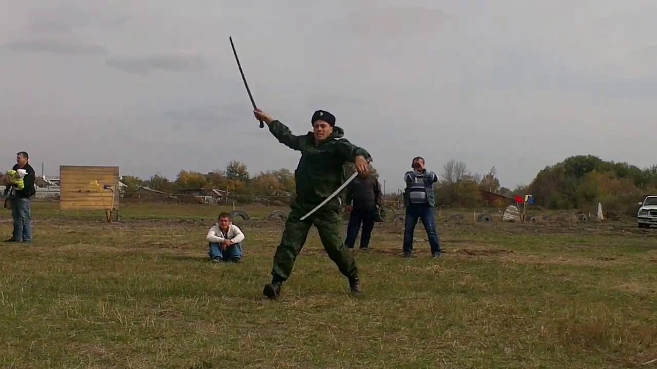 Фланкировка шашкой видео. Фланкировка казачьей шашкой. Казачка с шашкой фланкировка. Казак фланкировка шашкой. Фланкировка Казаков с шашками.