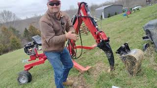 Nortrac backhoe ripper and 12" bucket teamed with mower+yard cart move a small apple tree.