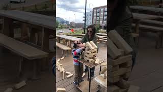 Oversized Jenga pieces falls on boys head as woman attempts to shield him