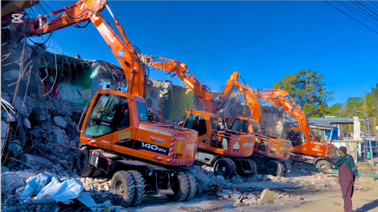 5 excavators working in same place for building demolition/five excavators in action