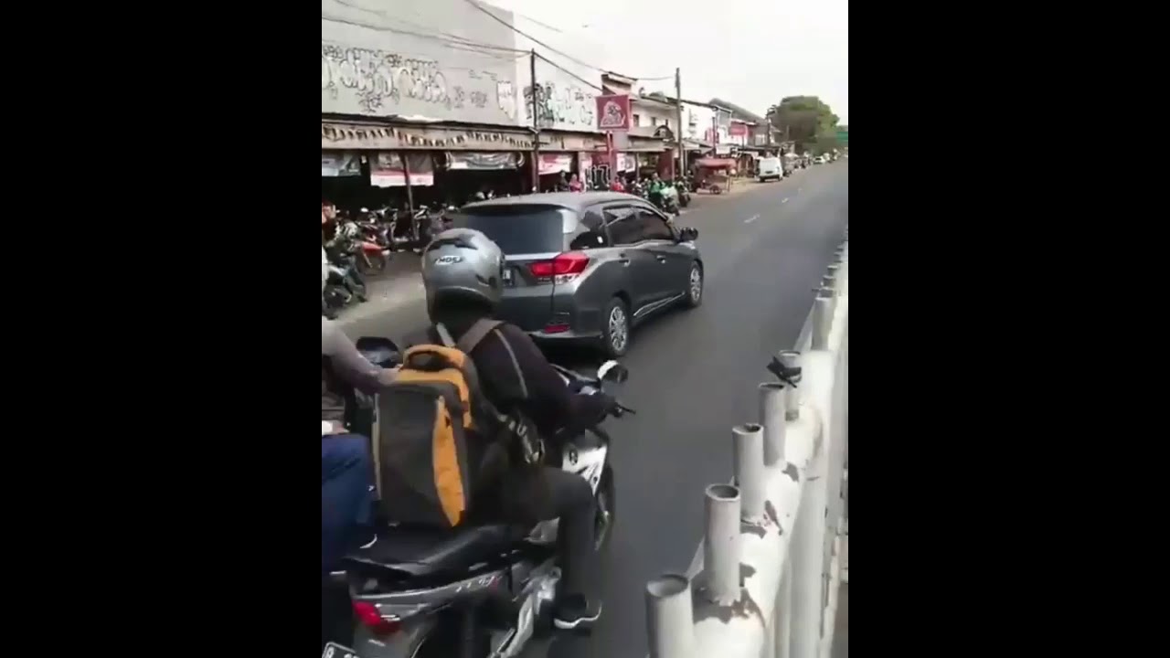 Kabur menolak ditilang, polisi terbawa diatas mobil.