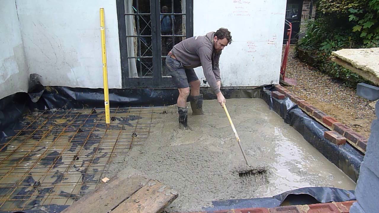 Wheelbarrowing the cement for the slab - YouTube