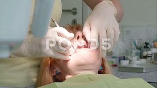 Female Dentist Performs Teeth Inspection Of Female Patient