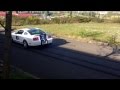 2007 shelby gt500 mustang doing a rolling burnout in front of the mustang shop