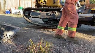 Caterpillar mechanic installing track back on new 303.5