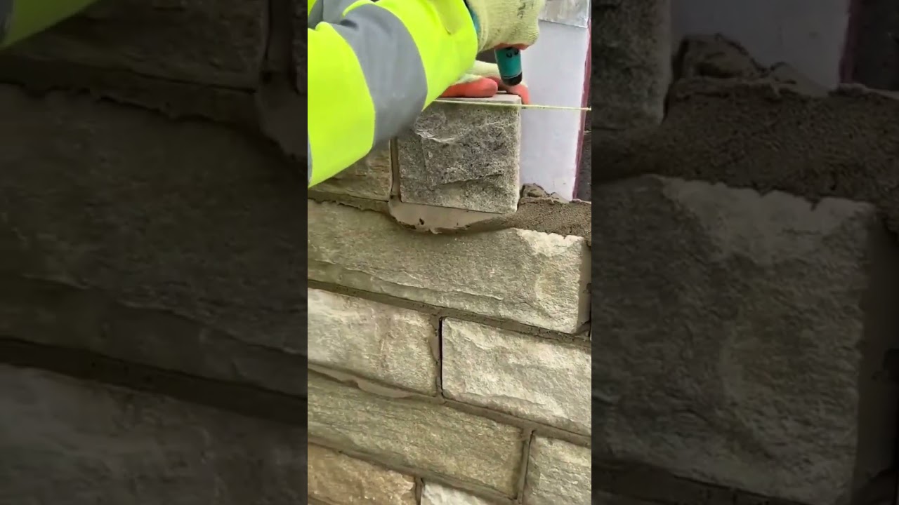 Worker leveling stone bricks precisely using a taut string line