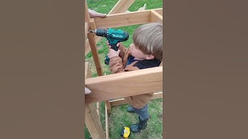 Brayden using a power tool with his dad