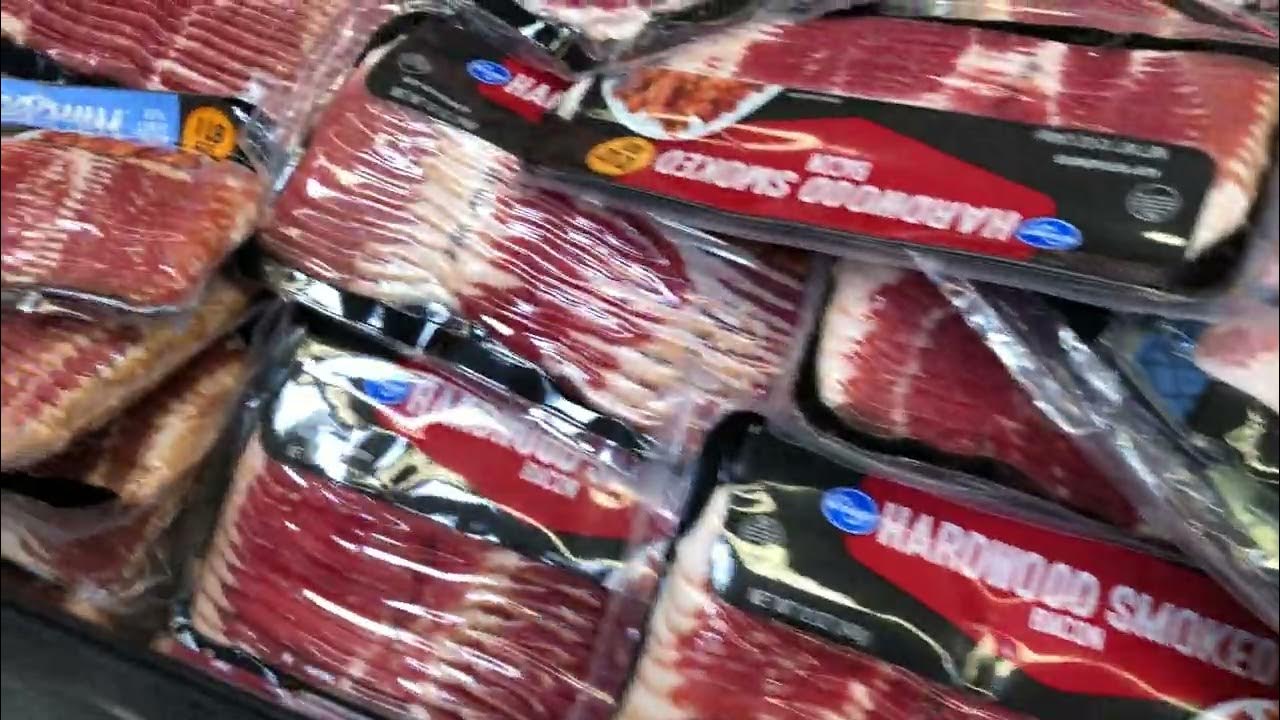 Many packs of Spoiled Rotten Bacon sitting in open top refrigerator at