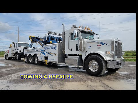 ROTATOR TOWING A LARGE HYRAILER TRUCK. 