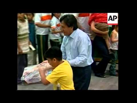 Embattled president hands out candies for the poor