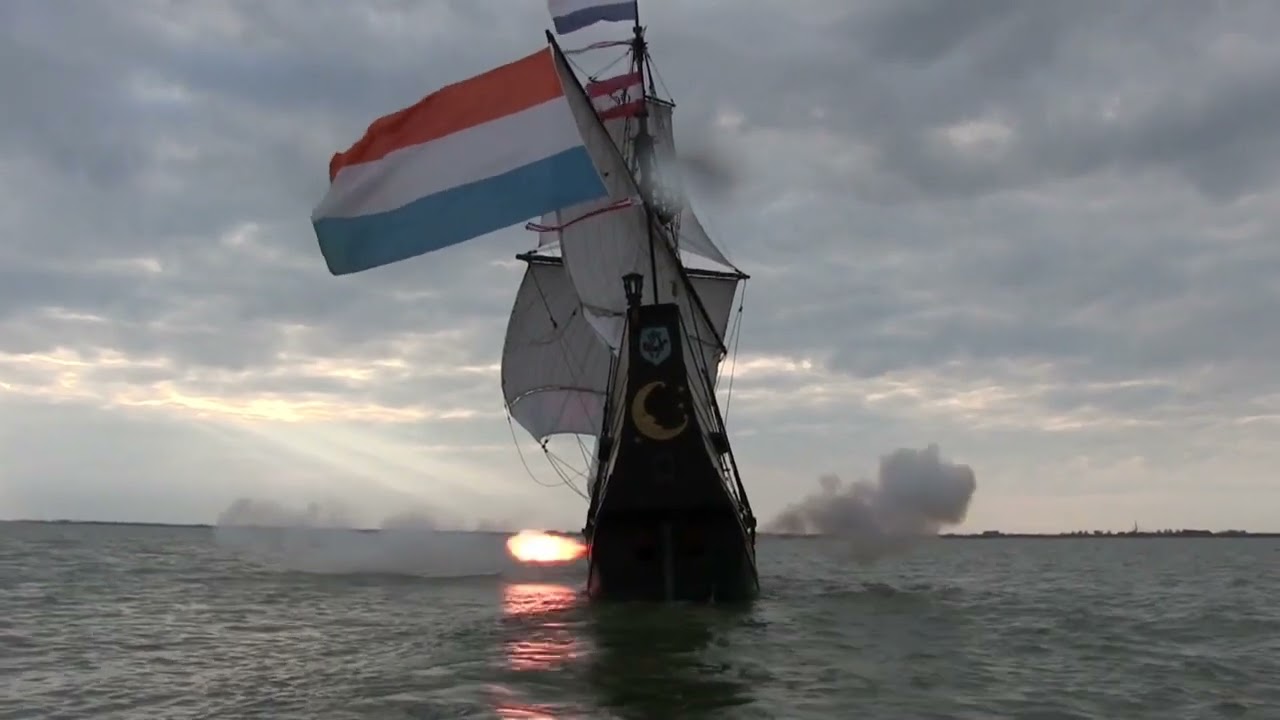 Early 17th century ship under sail and firing her guns.