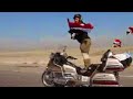 شخص يقود الدراجة واقفا ويحمل علم العراق من البصرة الى ذي قار 
