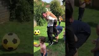 Guy picks up two others guys on his shoulders and as they fall one guys elbow hits little girl