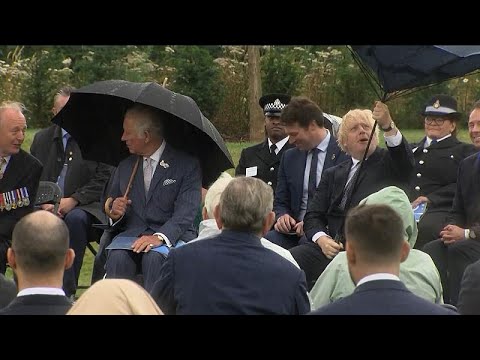 شاهد جونسون يحاول الحفاظ على ثبات مظلته تحت طقس عاصف خلال مناسبة رسمية