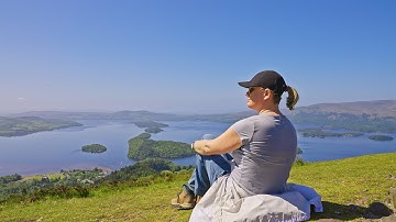 Parallax tracking a woman sitting on a grassy hillside with rolling hills, Conic Hill, Scotland