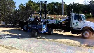 Flatbed Truck Delivering Wood With A Forklift