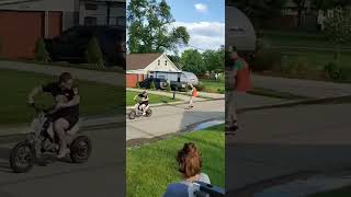 Skateboarder hitches a ride on back of dirt bike then lets go and falls to the ground