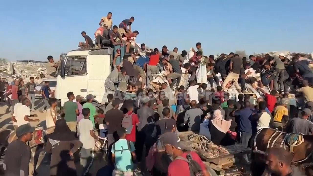 People crowd onto trucks to get aid in Morag area of Khan Younis