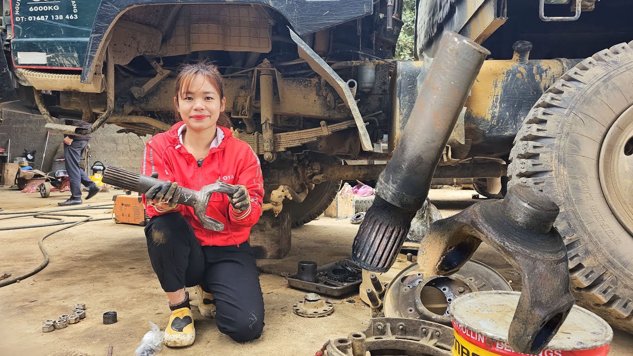 Mechanic girl replaces front axle for broken truck