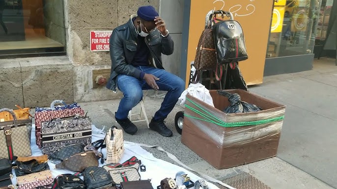 vendor illegally selling imitation name brand handbags on Canal Street  Manhattan New York Stock Photo - Alamy