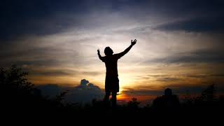 Silhouettes Of Relax Man With The Background Of The Sunset Sky