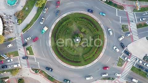 Vehicles on a busy roundabout junction. Traffic circle with a lot of cars. Top down aerial view ...