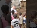 life of African orphans.  white man having fan with ugandan orphans