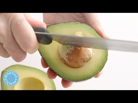 Man Removing a Pit from an Avocado Stock Photo - PixelTote