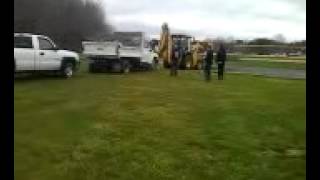 2 trucks , a dump truck and a 345 got stuck in mud