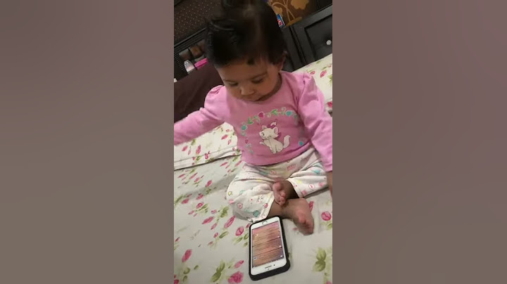 Baby playing with mobile phone.