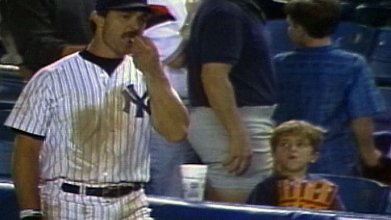 Don Mattingly helps himself to a young fans popcorn