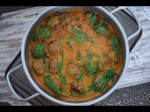 Tasty mutton meatballs with baby spinach in coconut sauce